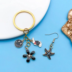 Detalle de dijes de dibujos animados con pendiente de estrella y llavero de conejo blanco