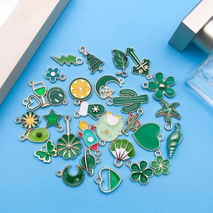 Détail de divers pendentifs en émail vert et alliage pour la création de bijoux DIY