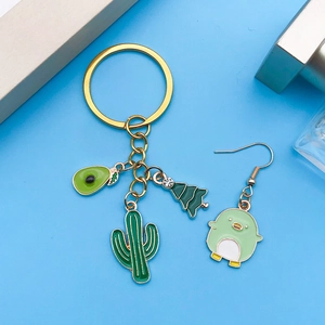 Gros plan de breloques de dessin animé à l'huile verte avec avocat et cactus sur fond bleu