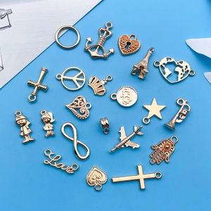 Collection of golden alloy travel-themed charms on blue background for DIY jewelry making