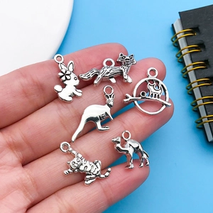 Macro view of six vintage silver animal charms for DIY jewelry making on a blue background