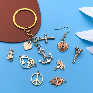 Close-up of gold alloy travel charms set with Eiffel Tower and heart pendants