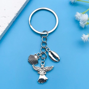 Détails des breloques vintage en argent avec coquillage et coquille sur un porte-clés