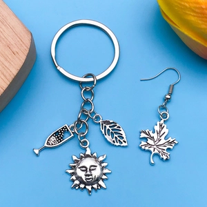 Détail de breloques en argent vintage avec boucle d'oreille feuille et porte-clés soleil