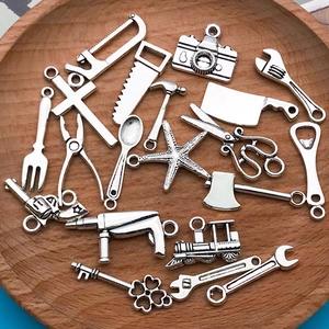 Détails macro de breloques en alliage d'argent antique avec outils et caméras