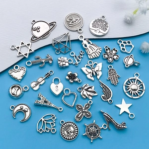 Detailed flat lay of vintage silver alloy charms including stars and Eiffel Tower for DIY