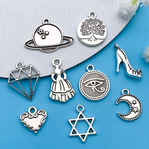 Detailed macro view of mixed vintage silver alloy charms featuring celestial and symbolic designs