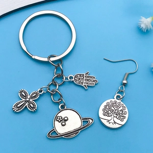 Detail of vintage silver charms featuring cross, hamsa hand, and tree of life motifs