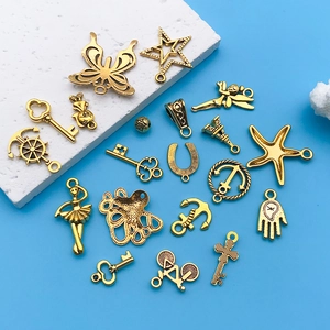 Macro shot of assorted vintage gold alloy pendants like anchors and keys on blue background