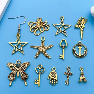Macro shot of assorted vintage gold alloy charms including butterfly and key on blue background