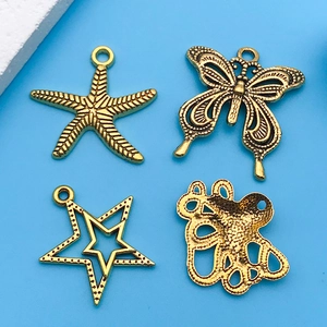 Detail of antique gold alloy charms featuring starfish, butterfly and nautical themes
