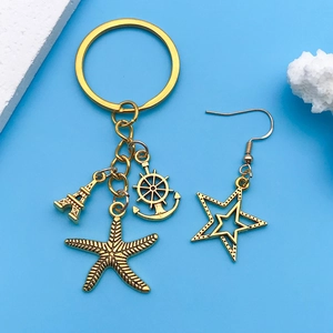 Detail of vintage gold alloy charms including Eiffel Tower and helm on light blue background