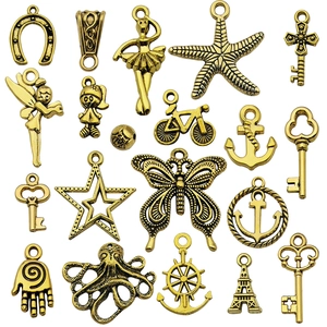 Collection of vintage gold alloy charms with anchors, keys, and butterflies for DIY jewelry