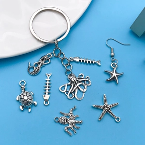 Macro detail of antique silver ocean charms including seahorse, turtle and starfish