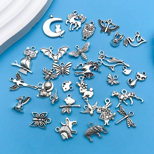Dettaglio di ciondoli vintage in argento con gufi e farfalle per gioielli fai-da-te