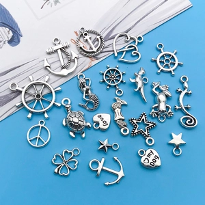 Close-up of vintage silver charms including anchor, mermaid and turtle for DIY jewelry