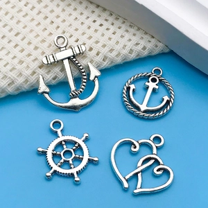 Macro view of silver nautical charms including anchors, a helm, and interlocking hearts