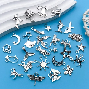 Macro view of vintage silver alloy charms featuring animals and celestial motifs for DIY jewelry