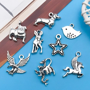 Macro view of vintage silver alloy animal charms including bulldog, bird and star pendants
