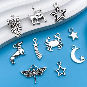 Macro detail of antique silver alloy charms including owls, stars and animals for DIY crafts