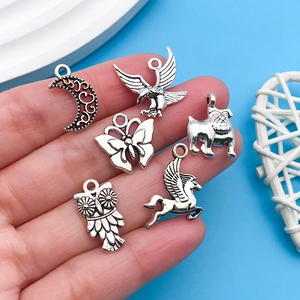 Macro view of antique silver alloy charms including owl, eagle, and moon for DIY jewelry