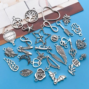 Flat lay of antique silver alloy charms including tree of life and heart for DIY jewelry