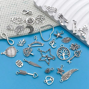 Detailed collection of vintage silver charms including wings and hamsa for DIY jewelry