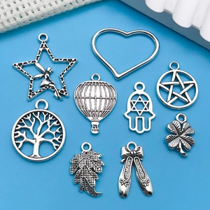 Detailed macro view of antique silver alloy charms including tree of life and hot air balloon