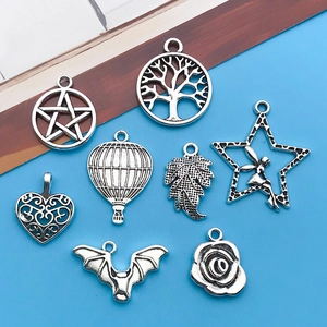 Close-up of vintage silver alloy charms featuring tree of life, star, and heart designs