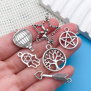 Close-up of antique silver alloy charms including hot air balloon and tree of life