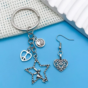 Macro detail of antique silver wing and fairy charms with intricate heart earring designs