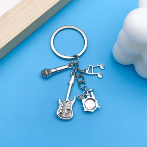 Detail of silver musical instrument keychain with guitar, drums and microphone charms