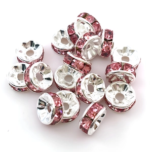 Nahaufnahme von 8mm silbernen Distanzperlen mit rosa Kristallen für DIY-Schmuckherstellung