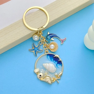Detail of marine keychain with blue starfish, pink dolphin and sea shell charms