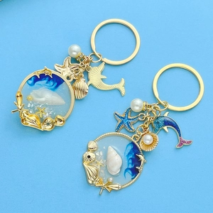 Detail of nautical keychain featuring blue dolphins and starfish with golden starfish charms