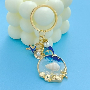 Detailed close-up of ocean-themed keychain with starfish, dolphin, and shell charms
