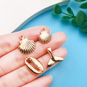 Detailed set of four KC gold marine pendants including seashells and mermaid tail for DIY charms