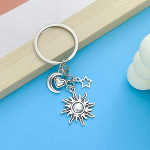 Detailed macro view of vintage silver moon, star, and sun alloy pendants on a keychain