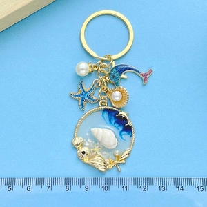 Blue ocean keychain with resin wave pendant, dolphin and starfish charms with golden ring