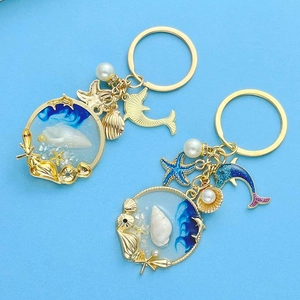 Nautical keychain set with blue ocean resin pendant, starfish, pearl and golden dolphin