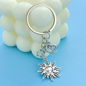 Detailed view of silver metal keychain with celestial sun moon and star charms