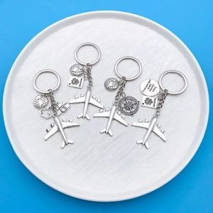 Travel keychain set with airplane, passport, and earth charms on a blue background