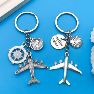 Detailed shot of travel keychains with airplane, compass and no matter where engraving