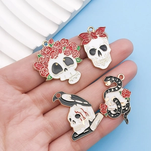 Schädel- und Rosen-Emaille-Anhänger für DIY-Schmuck, präsentiert in einer Handfläche