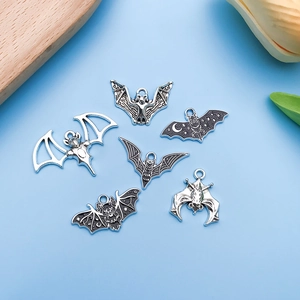 Detail view of assorted Halloween bat charms in silver and black alloy on light blue base