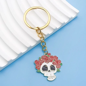 Detailansicht eines Totenkopf-Emaille-Anhängers mit roten Rosen am goldenen Schlüsselbund