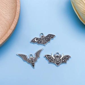 Detailed close-up of three gothic bat charms for DIY jewelry with black enamel finish