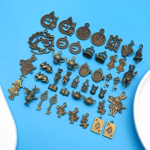 Macro shot of vintage bronze Alice in Wonderland charms on a bright blue backdrop