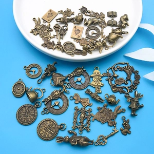 Close-up of vintage bronze Alice in Wonderland charms featuring rabbit and teapot shapes