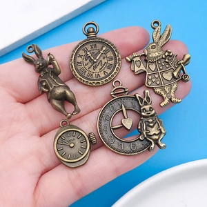 Detailed macro view of vintage bronze Alice in Wonderland charms held in hand